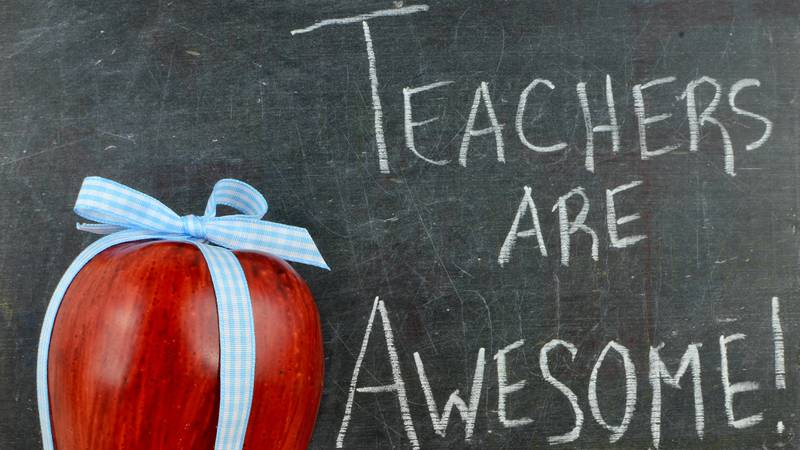Teachers are awesome written on a chalkboard next to a red apple.